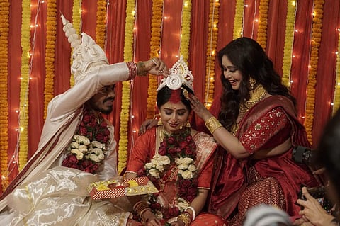 Chitrangada (centre) blushes as Sambit applies sindoor on her forehead, with RItabhari helping with the ritual