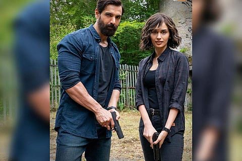 Chhillar is seen sporting short hair and holding a gun as she poses with Abraham
