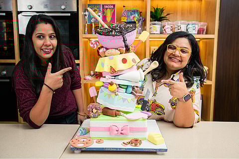 Aditi (Right) with a topsy turvy cake
