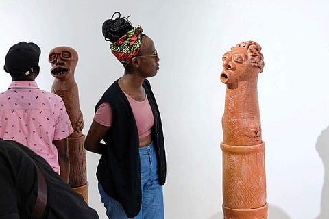 In frame: A lady looks at a sculpture piece during Lilian Nabulime's 'Olugamba exhibition at Xenson Art Space in Kamwokya