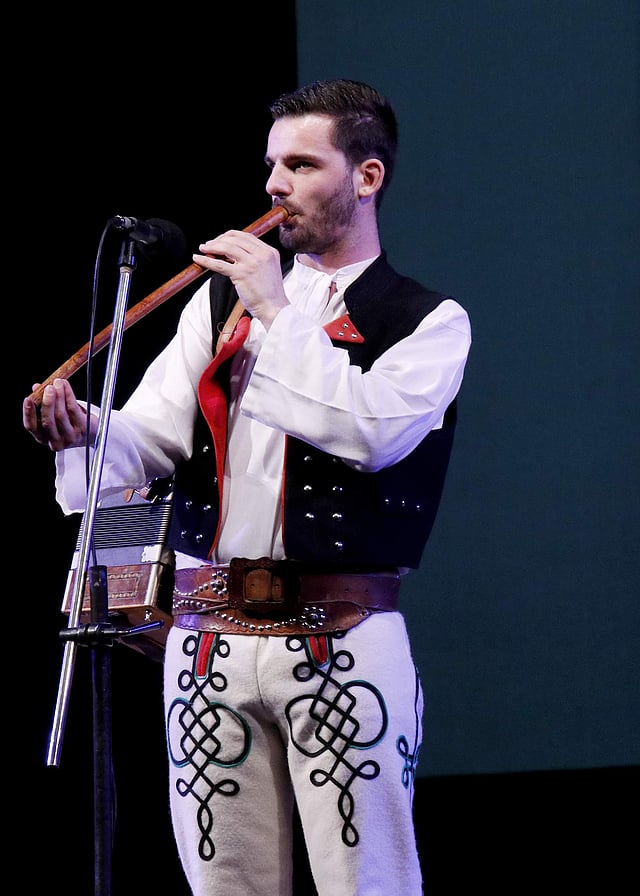 <em>A member of Rozsutec playing flute and heligonka</em>