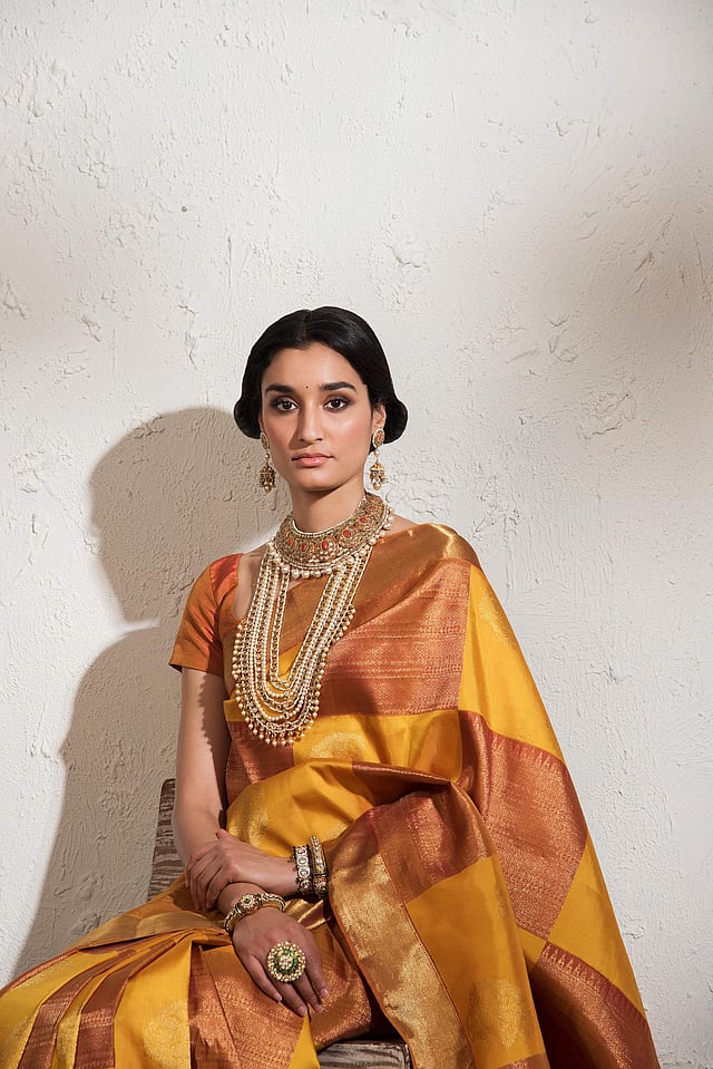 A model in a mustard and red sari from the collection