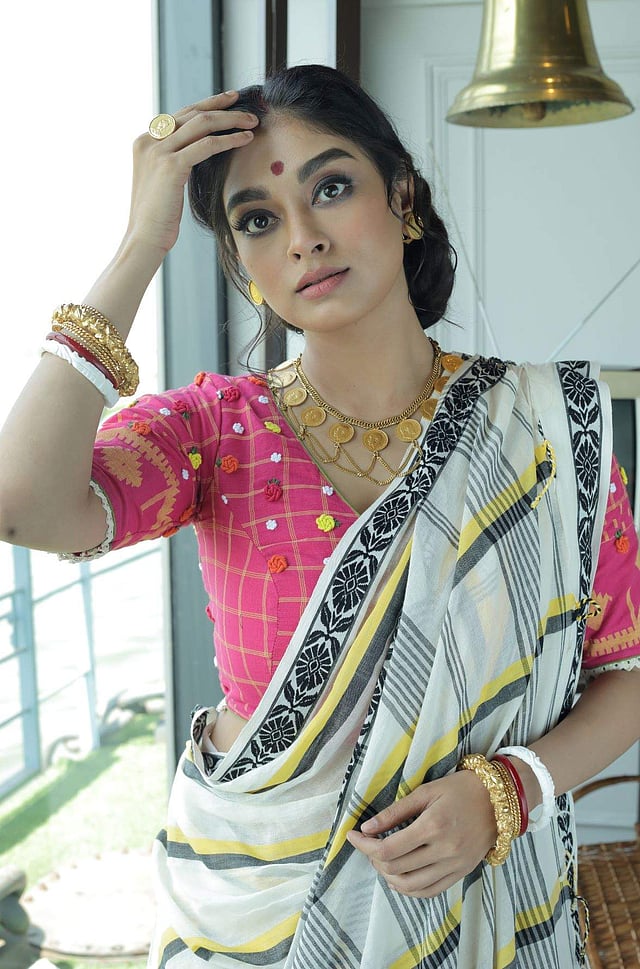 <em>A hand-woven striped cotton sari with a contrasting embroidered blouse, both by Parama Ghosh and guinea necklace and studs and amrita pak bala by A Sirkar</em>